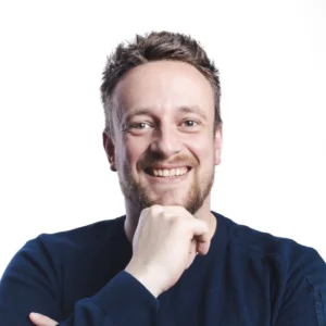Chris, creative developer bij WebMount, glimlacht in een professionele portretfoto met witte achtergrond.