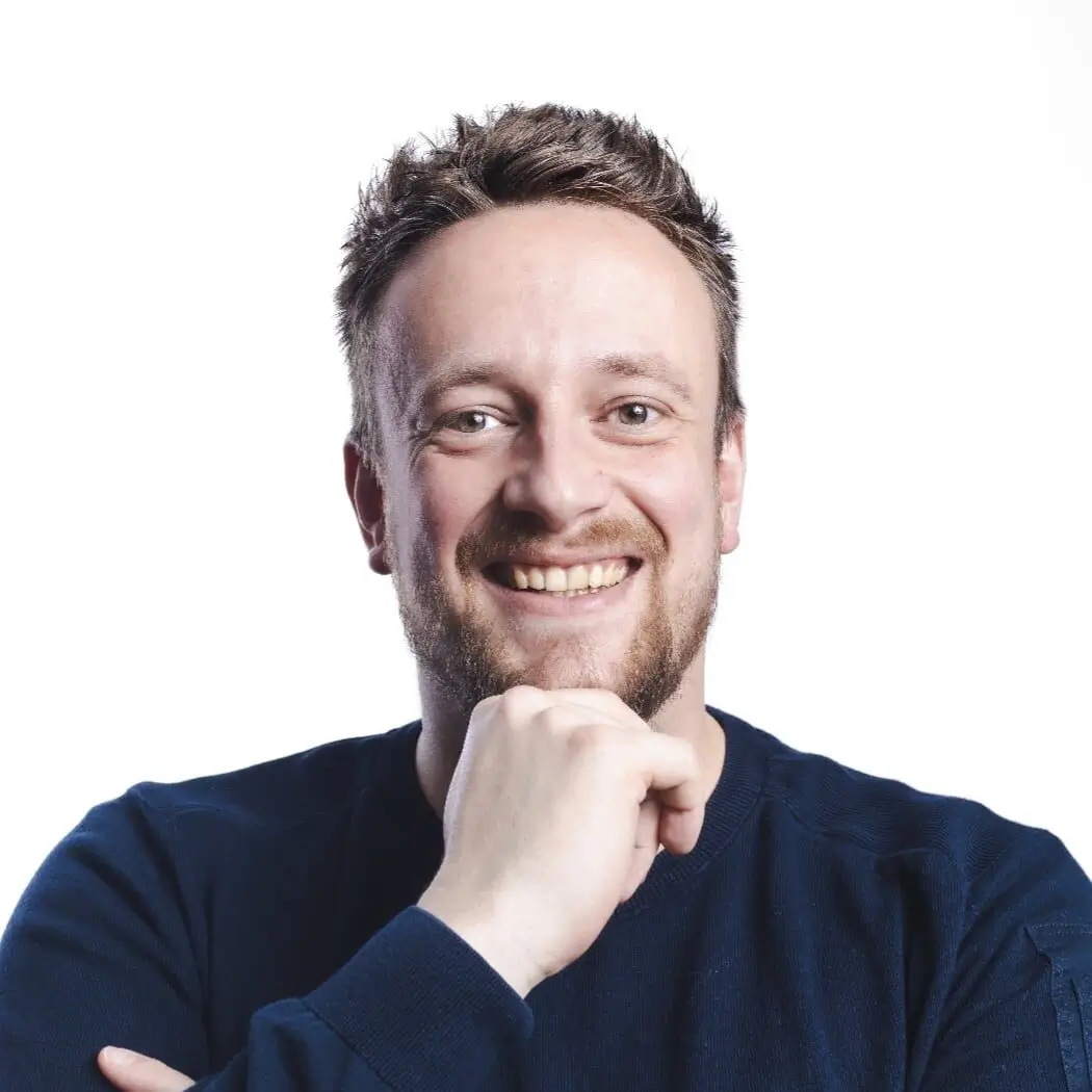 Chris, creative developer bij WebMount, glimlacht in een professionele portretfoto met witte achtergrond.